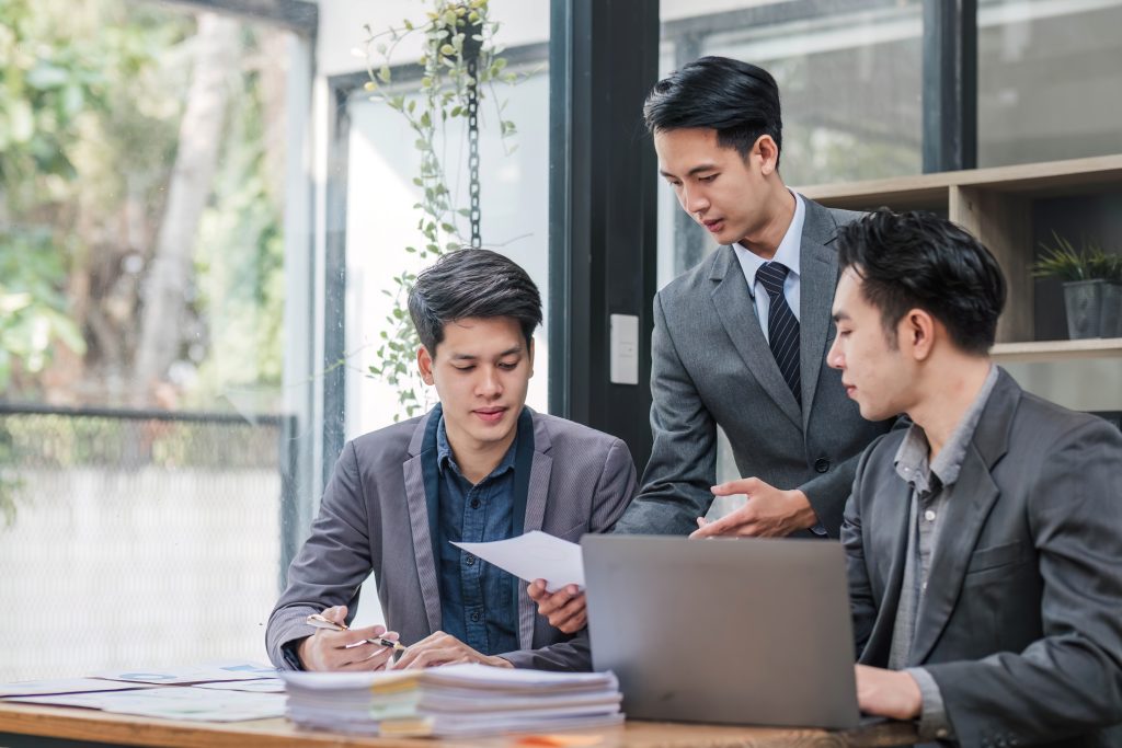 a group of men looking at papers
